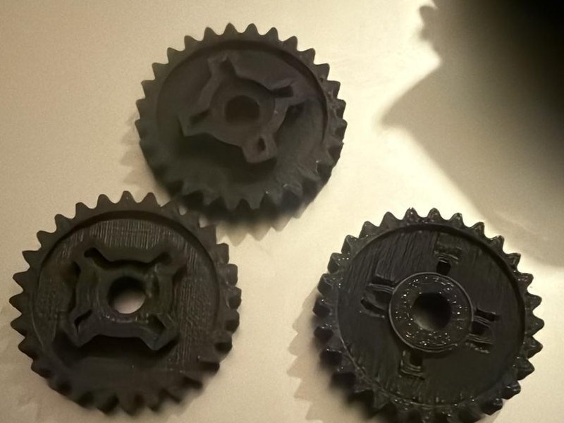 Tres engranajes negros impresos en 3D en ASA para la bomba de agua de una moto