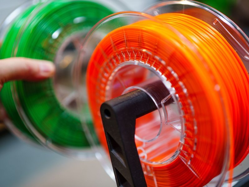 Bobinas de filamento para impresora 3D en color naranja y verde